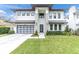 Modern house with stone accents, metal roof, and a spacious driveway at 3213 W Fair Oaks Ave, Tampa, FL 33611