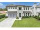 Modern two-story home with a metal roof, two-car garage, and landscaped lawn at 3213 W Fair Oaks Ave, Tampa, FL 33611