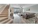 Spacious living room with L-shaped sectional sofa, tile floors, and view of the pool at 3322 Woodmont Dr, Parrish, FL 34219