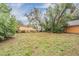 Large backyard with grassy area and partial view of neighboring buildings at 3409 E Comanche Ave, Tampa, FL 33610