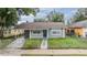 Newly painted gray house with a carport and walkway at 3409 E Comanche Ave, Tampa, FL 33610