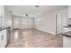 Open living room with wood floors, leading to kitchen at 3409 E Comanche Ave, Tampa, FL 33610