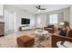 Living room with hardwood floors, staged furniture, and large TV at 3409 E Comanche Ave, Tampa, FL 33610