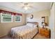 Cozy bedroom with floral bedding, wood nightstand and ceiling fan at 35138 Dale Ave, Zephyrhills, FL 33541