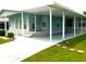 Light blue manufactured home with carport and landscaped front yard at 36819 Kiowa Ave, Zephyrhills, FL 33542