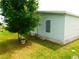 Side view of light blue single wide home at 36819 Kiowa Ave, Zephyrhills, FL 33542