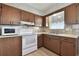 Kitchen with wood cabinets and white appliances at 380 137Th Avenue Cir, Madeira Beach, FL 33708