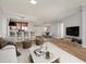 Open concept living area with hardwood floors, modern furniture, and kitchen access at 450 Knights Run Ave # 605, Tampa, FL 33602