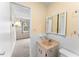 Bathroom with light wood vanity, white tile, and a view into the bedroom at 4746 Azalea Dr # 203C, New Port Richey, FL 34652