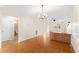 View of the dining area from the kitchen, showing wood floors and a partial bathroom at 4746 Azalea Dr # 203C, New Port Richey, FL 34652