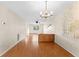 Dining room with laminate wood floor, a chandelier, and a view into the living room at 4746 Azalea Dr # 203C, New Port Richey, FL 34652