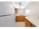 Small kitchen with wood cabinets, white appliances, and tiled floor at 4746 Azalea Dr # 203C, New Port Richey, FL 34652