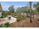 Landscaped backyard with a patio, garden, and mature trees at 546 Orangewood Dr, Dunedin, FL 34698