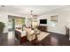 Living area with hardwood floors, beige couch, and sliding doors opening to the pool at 5701 S Macdill Ave, Tampa, FL 33611