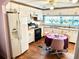 Bright kitchen with white cabinets, wood flooring, and a table for casual dining at 9790 66Th N St # 248, Pinellas Park, FL 33782