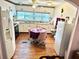 View of a kitchen with white cabinets, wood floors and a small dining area at 9790 66Th N St # 248, Pinellas Park, FL 33782