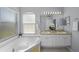Bathroom with double vanity, soaking tub, and window at 10038 Reagan Dairy Trl, Bradenton, FL 34212