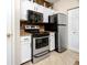 Kitchen features granite countertops, white cabinets, and stainless steel appliances at 10764 70Th Ave # 1303, Seminole, FL 33772