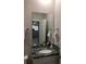 Bathroom with granite vanity and large mirror reflecting kitchen at 10913 Kidron Valley Ln, Tampa, FL 33625