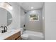 Clean bathroom with a bathtub, gray tile, and a modern vanity at 11901 Munbury Dr, Dade City, FL 33525