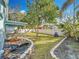 Large backyard with a pond feature, mature trees, and a grassy area at 14721 Condor Pass, Clearwater, FL 33760