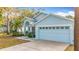 The home features a light blue exterior, two-car garage, and landscaping at 14721 Condor Pass, Clearwater, FL 33760