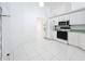 White kitchen with stainless steel appliances and tile floor at 14721 Condor Pass, Clearwater, FL 33760