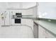 White kitchen with stainless steel appliances and green countertops at 14721 Condor Pass, Clearwater, FL 33760