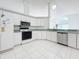 Kitchen features white cabinets, stainless steel appliances, and tile floor at 14721 Condor Pass, Clearwater, FL 33760