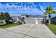 Gray house with three-car garage and lush landscaping at 17721 Bright Wheat Dr, Lithia, FL 33547