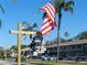 Community entrance sign of Elmwood 55+ Circle with parked cars and palm trees at 214 Elmwood Cir # 214, Seminole, FL 33777