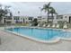 Community pool with lounge chairs and surrounding buildings at 214 Elmwood Cir # 214, Seminole, FL 33777