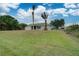 Single story home with large grassy yard and palm trees at 2369 N Biscayne Dr, North Port, FL 34291