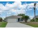 Single-story home with attached garage and landscaped yard at 2369 N Biscayne Dr, North Port, FL 34291