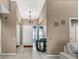 Bright entryway with mirrored walls, chandelier, and tile flooring at 3028 Summervale Dr, Holiday, FL 34691