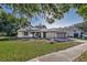 House with a lush lawn, solar panels, and a paved driveway at 3028 Summervale Dr, Holiday, FL 34691