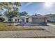 Single-story home with a gray roof, solar panels, and a paved driveway at 3028 Summervale Dr, Holiday, FL 34691
