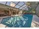 Relaxing screened pool with patio furniture and grill at 3028 Summervale Dr, Holiday, FL 34691