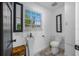 Small bathroom with pedestal sink, toilet and mirrors at 3031 W Asbury Pl, Tampa, FL 33611