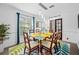 Bright dining room with glass-top table and six chairs, stylish rug and window curtains at 3031 W Asbury Pl, Tampa, FL 33611