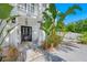 Front entrance with black door, stone tile, and lush tropical plants at 3031 W Asbury Pl, Tampa, FL 33611