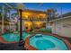 Evening view of the home's exterior, pool, and patio at 3031 W Asbury Pl, Tampa, FL 33611