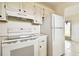 Kitchen features white cabinets, appliances, and tile floor at 402 Dorchester Pl # 28, Sun City Center, FL 33573