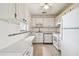 Full view of kitchen with white cabinets and appliances at 402 Dorchester Pl # 28, Sun City Center, FL 33573