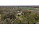 House nestled in a rural setting with large trees and farmland at 4156 Mcintosh Rd, Dover, FL 33527
