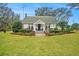 White house with a porch and lush green lawn at 4156 Mcintosh Rd, Dover, FL 33527