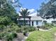 White cottage with pergola, lush landscaping, and walkway at 4156 Mcintosh Rd, Dover, FL 33527