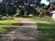 Landscaped yard with a gravel driveway and mature trees at 4156 Mcintosh Rd, Dover, FL 33527