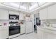 White kitchen with appliances, and view to dining area at 4500 38Th S St, St Petersburg, FL 33711