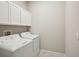 Laundry room with washer, dryer, and overhead cabinets at 5305 Tulip Drop Dr, Wimauma, FL 33598